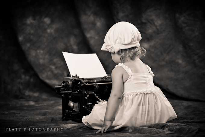 A child portrait. A young girl and an old typewriter.
