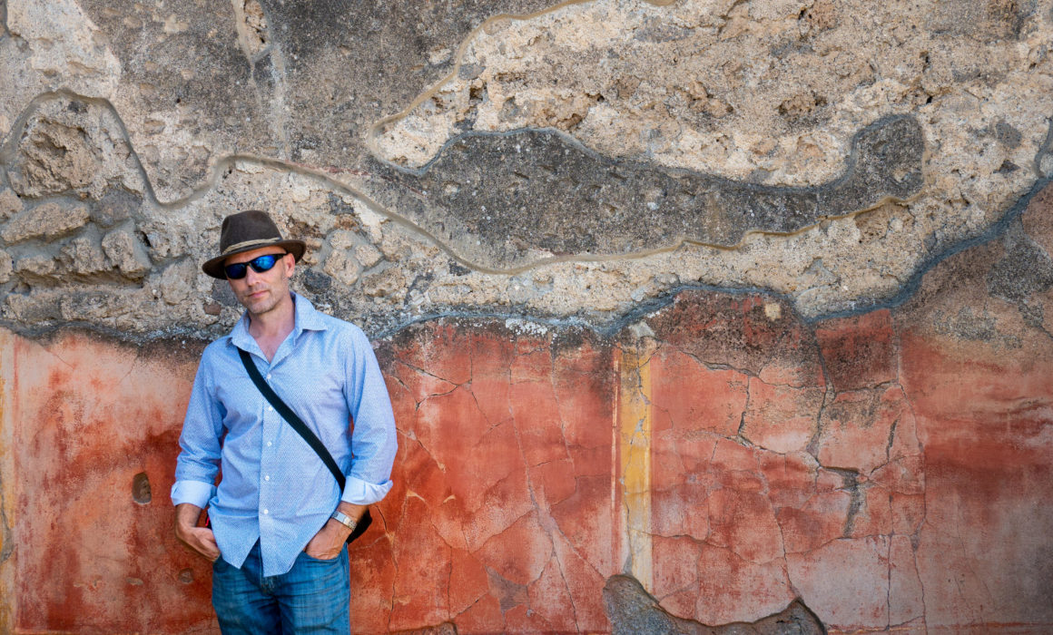 Portrait of international photographer, Jared Platt in Pompeii next to the ruins.